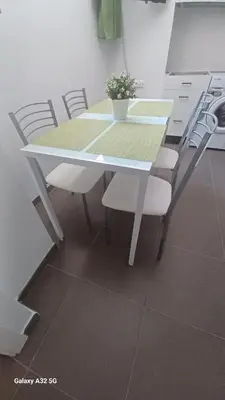 a white table and chairs with a potted plant on it at Sanlucarshine apartamento con piscina in Sanlúcar de Barrameda