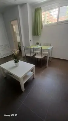a living room with two tables and a table and chairs at Sanlucarshine apartamento con piscina in Sanlúcar de Barrameda