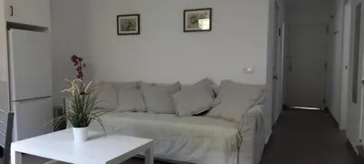 a living room with a couch and a table at Sanlucarshine apartamento con piscina in Sanlúcar de Barrameda