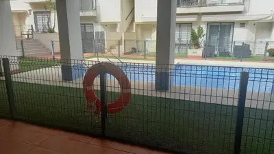 a net in front of a swimming pool at Sanlucarshine apartamento con piscina in Sanlúcar de Barrameda