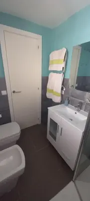 a bathroom with a white toilet and a sink at Sanlucarshine apartamento con piscina in Sanlúcar de Barrameda