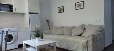 a living room with a couch and a table at Sanlucarshine apartamento con piscina in Sanlúcar de Barrameda