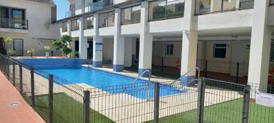 an empty swimming pool in front of a building at Sanlucarshine apartamento con piscina in Sanlúcar de Barrameda