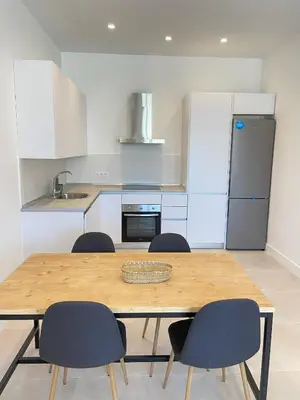 a kitchen with a wooden table and four chairs at Apartamentos a estrenar de dos dormitorios in San Fernando