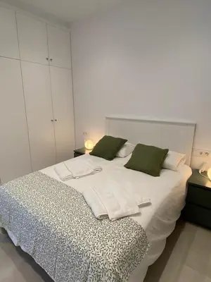 a bedroom with a large white bed with green pillows at Apartamentos a estrenar de dos dormitorios in San Fernando