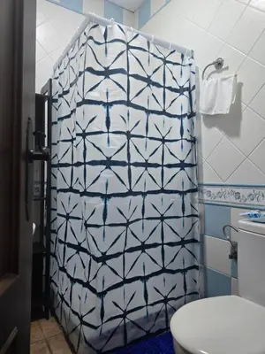 a bathroom with a blue and white shower curtain at Sancti Petri in Chiclana de la Frontera