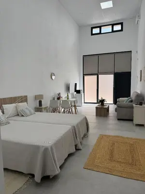 a white room with two beds and a couch at Apartamento Loft nuevo a 5 min de la playa in Cádiz