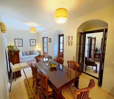 a dining room and living room with a table and chairs at Casa de Medina in Medina Sidonia