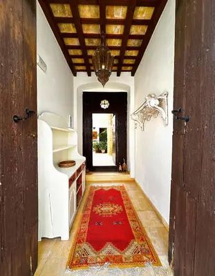 a hallway with a door and a red rug at Casa de Medina in Medina Sidonia