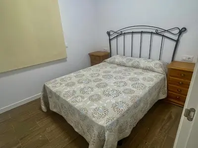 a small bedroom with a bed and a dresser at Preciosa casa Sol y Luna in Chiclana de la Frontera