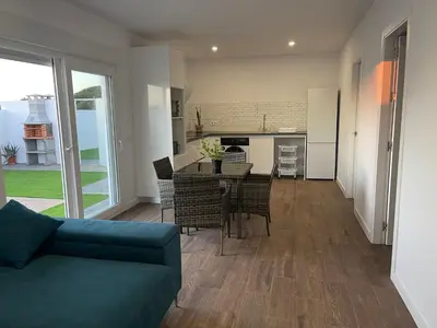 a living room with a couch and a table with chairs at Preciosa casa Sol y Luna in Chiclana de la Frontera