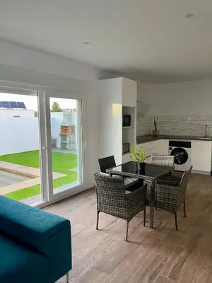 a living room with a blue couch and a table and chairs at Preciosa casa Sol y Luna in Chiclana de la Frontera