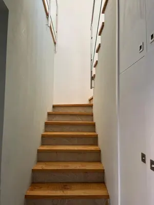 a staircase in a house with white walls and wooden stairs at Mi Teja in Chiclana de la Frontera