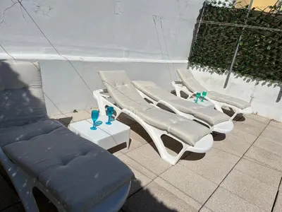 a group of lounge chairs and drinks on a patio at Mi Teja in Chiclana de la Frontera