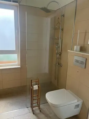 a bathroom with a toilet and a glass shower at Mi Teja in Chiclana de la Frontera