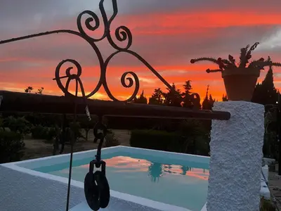 a swimming pool with a sunset in the background at Campito cerca del mar 