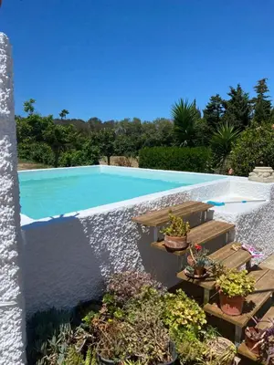 a swimming pool with a water feature and potted plants at Campito cerca del mar 