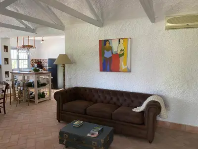 a living room with a couch and a painting on the wall at Campito cerca del mar 