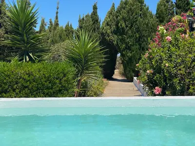 a garden with a swimming pool and trees and plants at Campito cerca del mar 