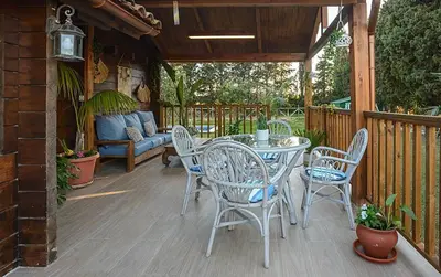 a patio with a table and chairs on a deck at Casa Pinares de Roche tres dormitorios in Cádiz