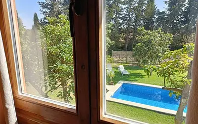 a window with a view of a swimming pool at Casa Pinares de Roche tres dormitorios in Cádiz