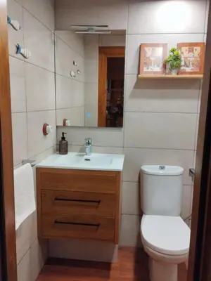 a bathroom with a toilet and a sink and a mirror at Casa Pinares de Roche tres dormitorios in Cádiz