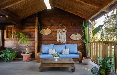 a blue couch on a wooden patio with a table at Casa Pinares de Roche tres dormitorios in Cádiz