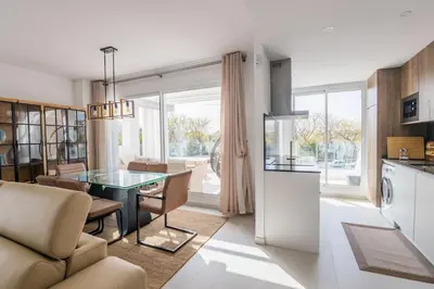 a kitchen and a living room with a table in a room at Luxury Beach Townhouse Retreat in Cádiz