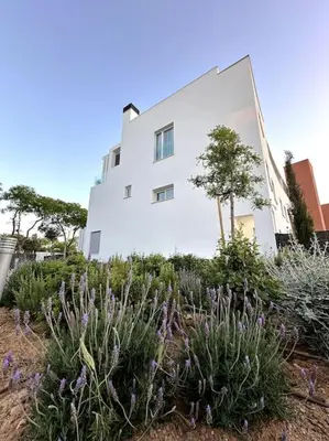 a white building with purple flowers in front of it at Luxury Beach Townhouse Retreat in Cádiz