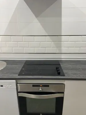 a stove top oven in a kitchen with white tiles at La casa de Cris in Sanlúcar de Barrameda