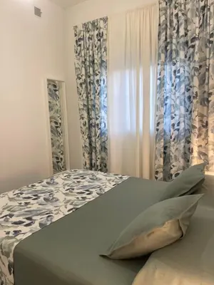 a bedroom with a bed with blue and white curtains at La casa de Cris in Sanlúcar de Barrameda