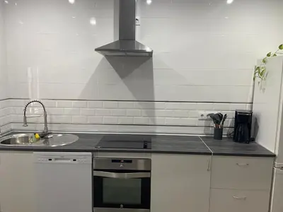 a kitchen with a sink and a stove top oven at La casa de Cris in Sanlúcar de Barrameda