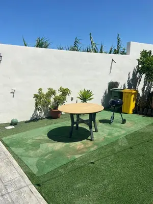 a picnic table and a chair in a yard at La casa de Cris in Sanlúcar de Barrameda