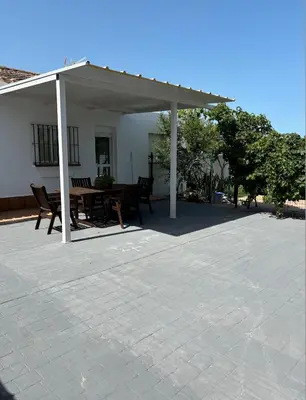 a pavilion with a table and chairs on a patio at Villa con piscina in Chiclana de la Frontera