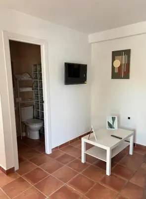 a living room with a table and a toilet at Villa con piscina in Chiclana de la Frontera