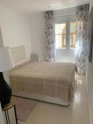 a bedroom with a large bed and a window at Casa Calle Merced in Cádiz