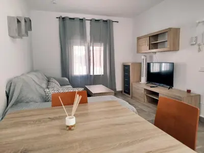 a living room with a table and a television at Casa Chiclana Centro in Chiclana de la Frontera