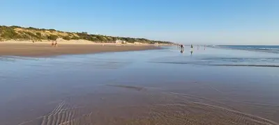 a group of people walking on the beach at Casa Chiclana Centro in Chiclana de la Frontera