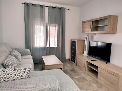 a living room with a couch and a flat screen tv at Casa Chiclana Centro in Chiclana de la Frontera