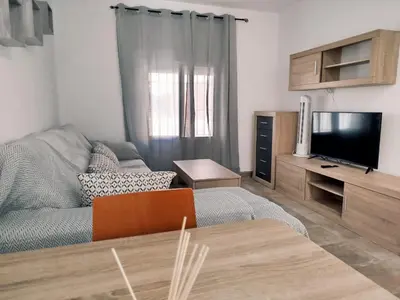 a living room with a couch and a flat screen tv at Casa Chiclana Centro in Chiclana de la Frontera
