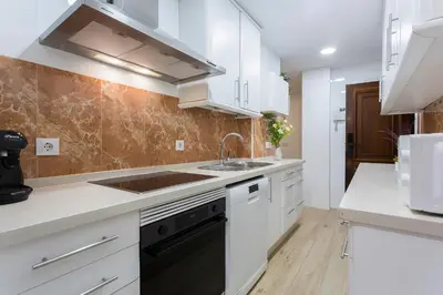 a kitchen with white cabinets and a sink at Plaza Caballo 3 Dormitorios Vistas in Jerez de la Frontera