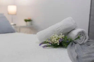 a person holding a bouquet of flowers on a bed at Plaza Caballo 3 Dormitorios Vistas in Jerez de la Frontera