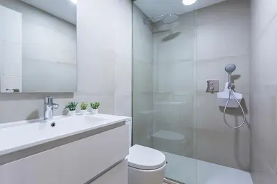 a white bathroom with a sink and a toilet at Plaza Caballo 3 Dormitorios Vistas in Jerez de la Frontera
