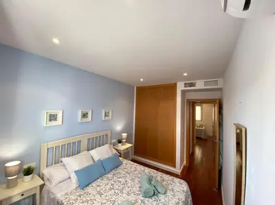 a bedroom with a large bed with blue pillows at Apartamento Mati, Terraza 55 m2 in Sanlúcar de Barrameda