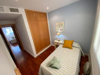 a bedroom with a bed with a yellow pillow on it at Apartamento Mati, Terraza 55 m2 in Sanlúcar de Barrameda
