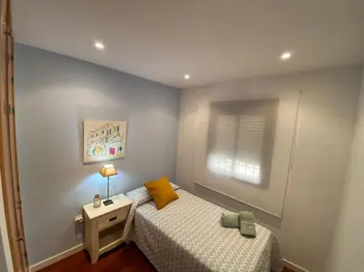 a bedroom with two beds and a lamp and a window at Apartamento Mati, Terraza 55 m2 in Sanlúcar de Barrameda