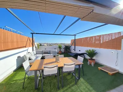 a patio with a table and chairs and a couch at Apartamento Mati, Terraza 55 m2 in Sanlúcar de Barrameda