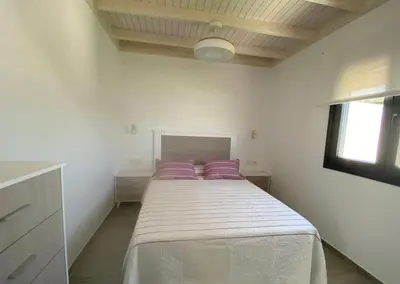 a bedroom with a large bed with purple pillows at Casa Lili in Conil de la Frontera