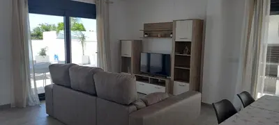 a living room with a couch and a television at Casa Lili in Conil de la Frontera