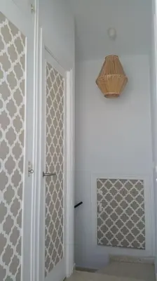 a hallway with a door and a chandelier at Estupendo adosado en La Barrosa, a 700 m de la Playa in Chiclana de la Frontera
